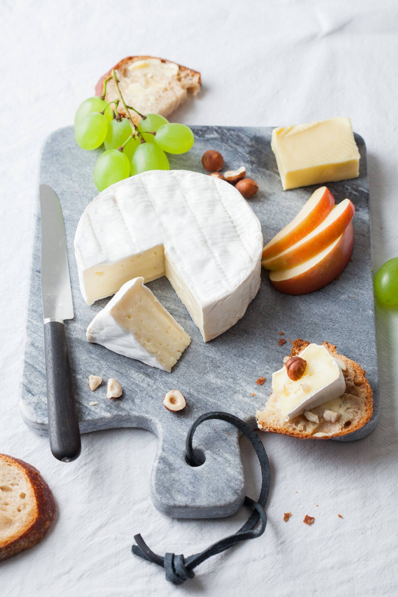 cheese platter with ile de france camembert, apple slices and grapes