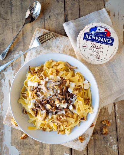 pasta dish with mushrooms, nuts and melted ile de france brie