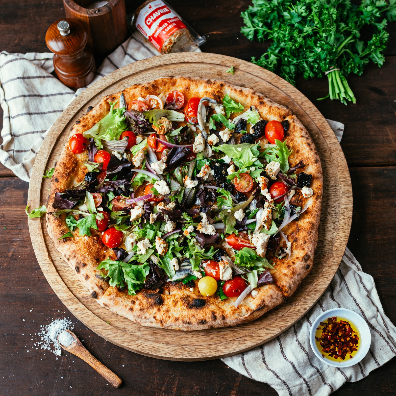 homemade pizza with greens, anchovies and Chavrie sundried tomatoes & garlic