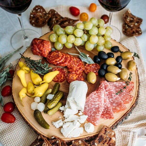 chavrie goat cheese log board with charcuterie, grapes, olives